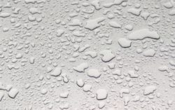 Fragment of gray surface of car, covered with water drops different sizes during a rain